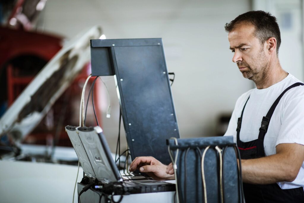 Technician diagnosing HVAC and building controls using a laptop